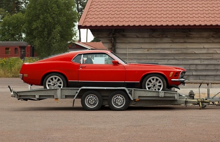 Red Ford Mustang on a trailer.
