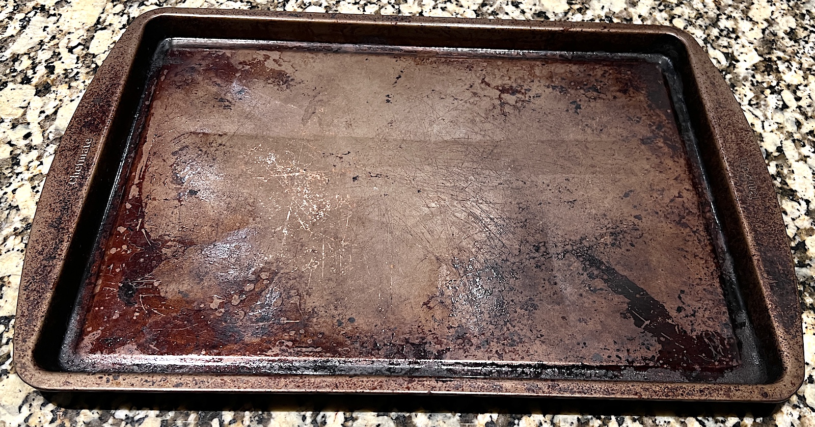 Used baking sheet on a stone kitchen counter