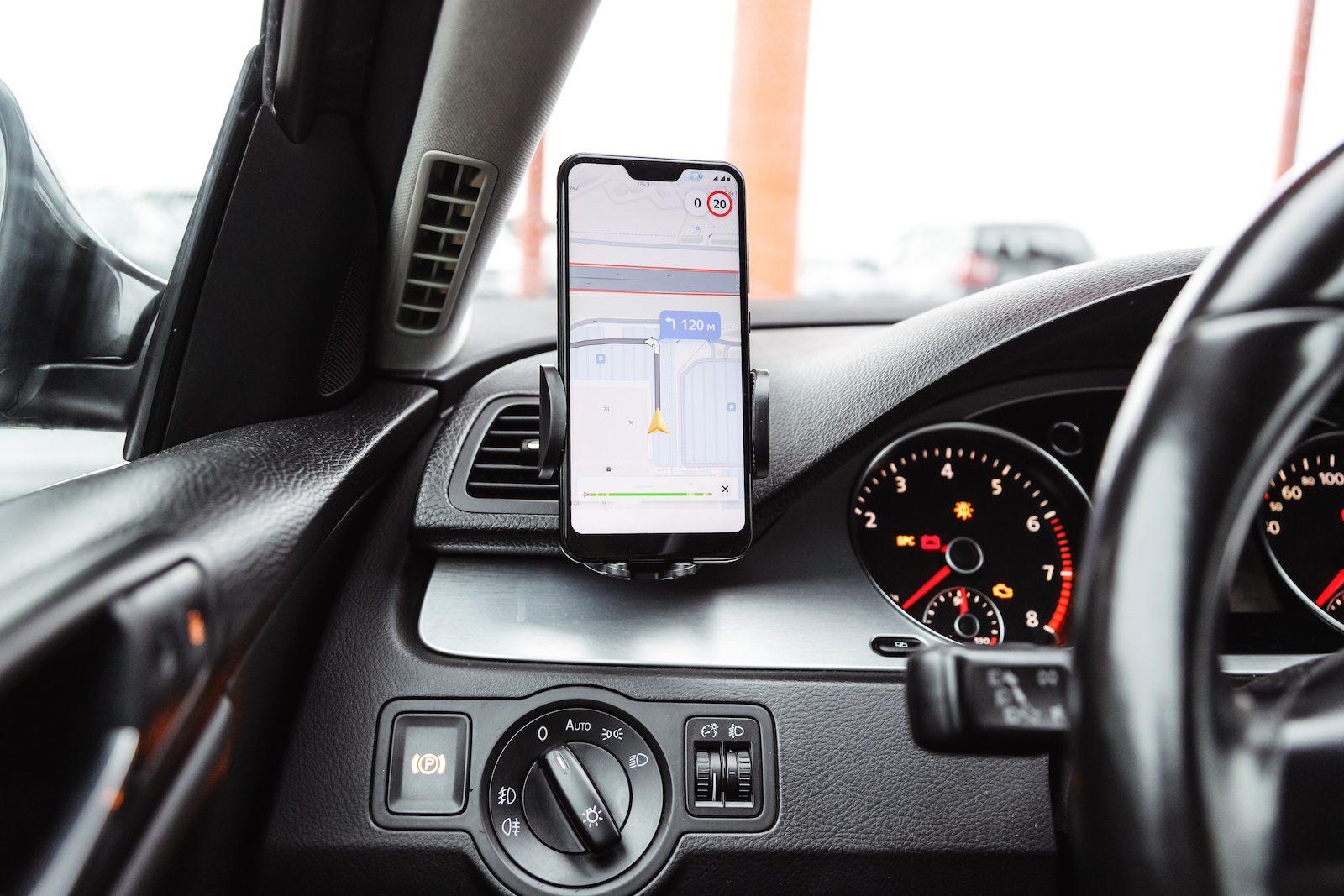 Smartphone displaying navigation screen in air vent mount to the left of the steering wheel.