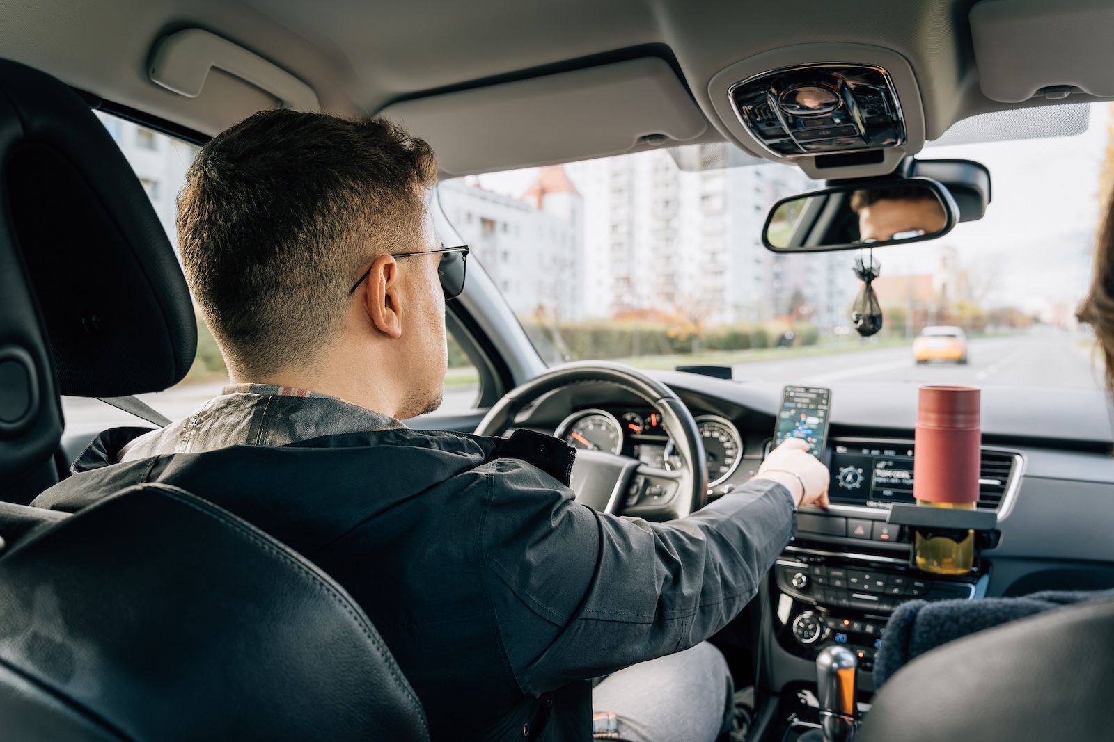 Driving using a smartphone in an HVAC vent-mount holder.