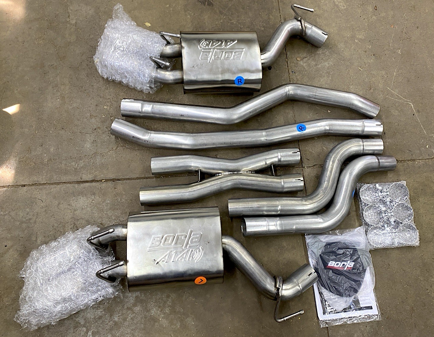 Borla cat-back exhaust system for the Chevrolet-Camaro ZL1, displayed on a concrete surface.