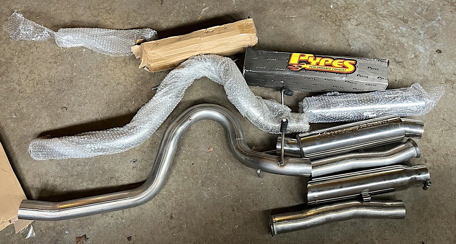 Pypes cat-back-exhaust kit displayed on a concrete floor.