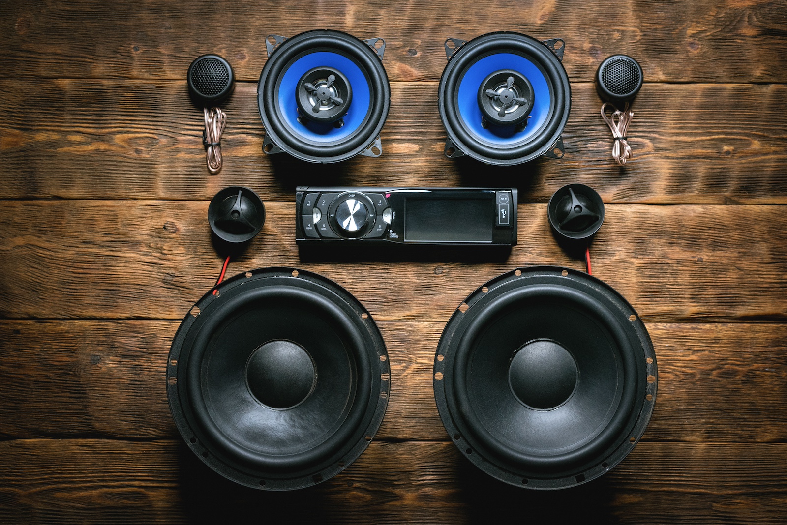 A car audio system with component speakers on a wooden workbench.