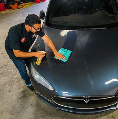 Technician applying Chemical Guys Blazin' Banana spray wax.