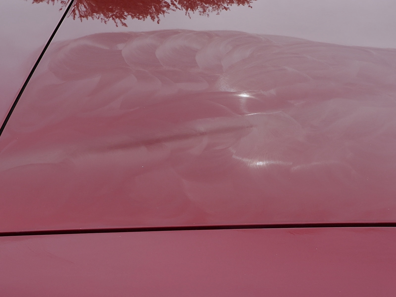 The car wax on this red car is hazed and ready to be removed with a microfiber towel.