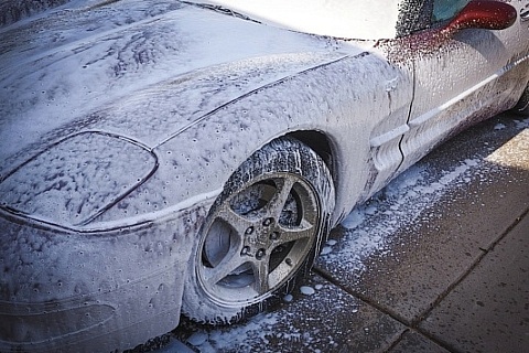 A red Corvette covered in foam.