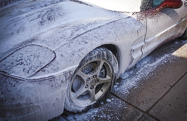 A red Corvette covered in foam.