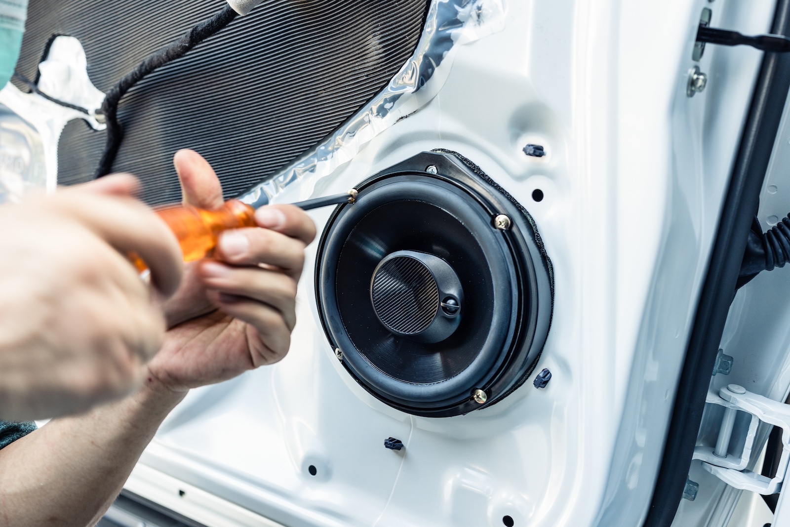 Installing a new speaker in a car door.