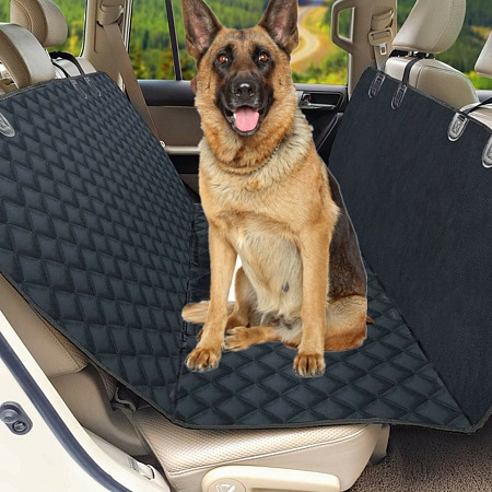 German Shepard sitting on a car seat protector.