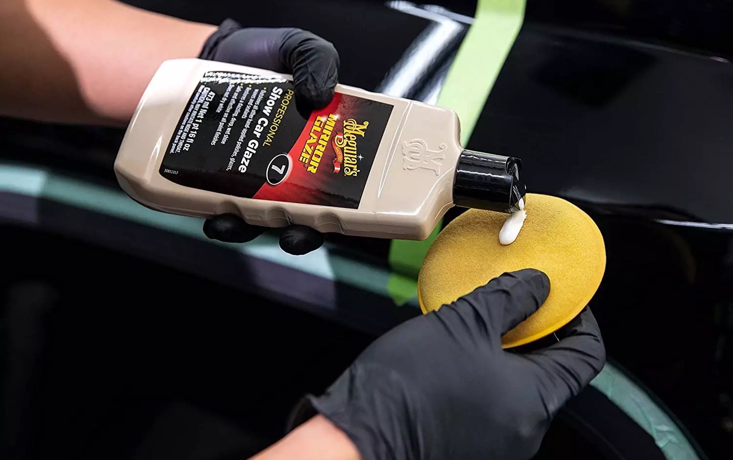 A detailer wearing black nitrile gloves applies a spot of Meguiars Number 7 to an applicator pad.