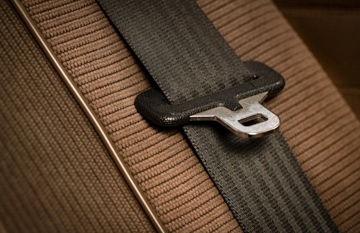 Brown seat belt and velour upholstery in classic car.