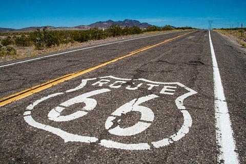 Route 66 logo on highway leading to the horizon.